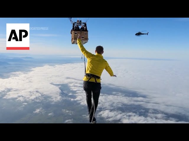 Slackliners balance between hot air balloons at height of 2,500 meters in world record