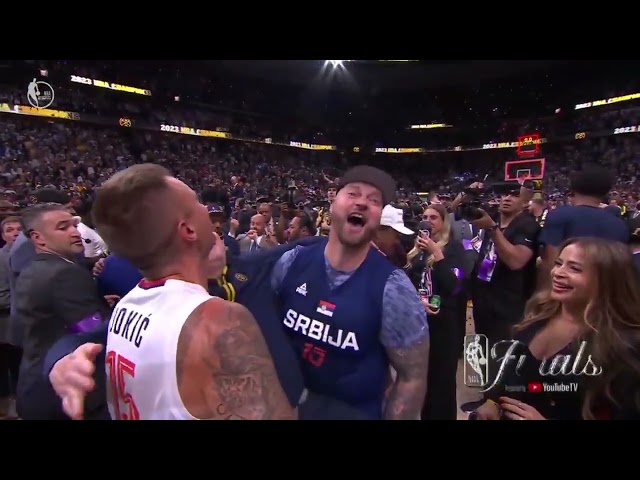 Nuggets head coach Michael Malone being lifted up by the Jokic brothers