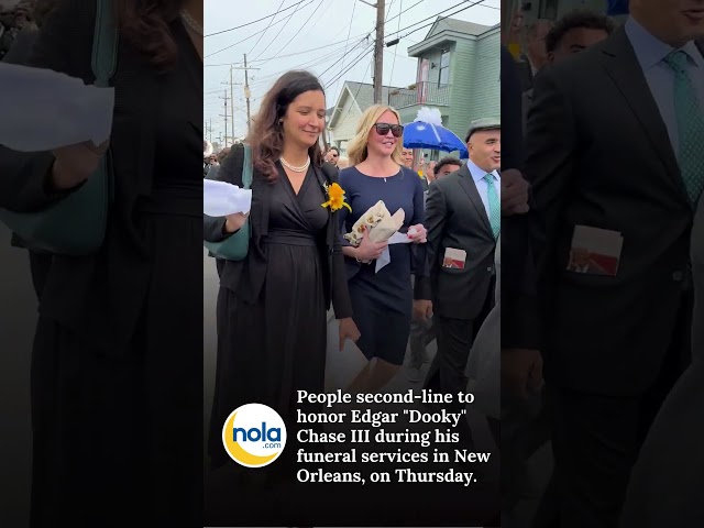 People gather for a second-line to honor Edgar "Dooky" Chase III during his funeral in New Orleans.