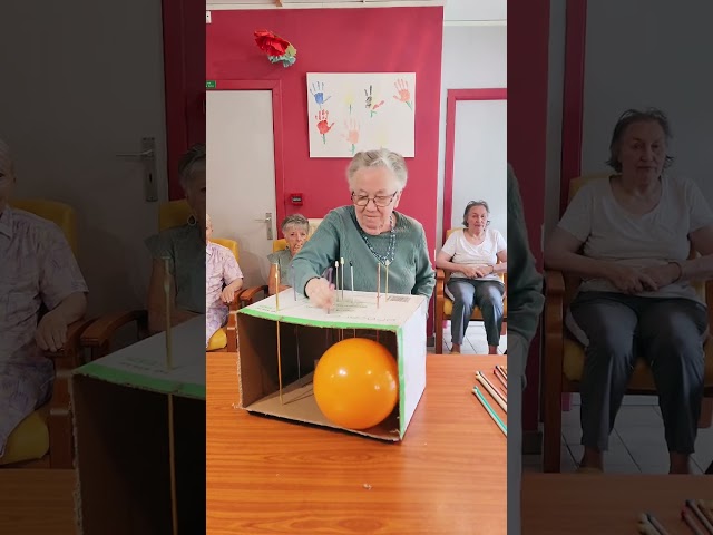 Players push long pins through a cardboard box attempting to pop the balloon!